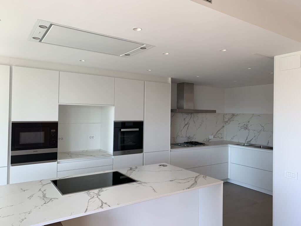 cocina moderna blanca con isla central y electrodomésticos Miele integrados