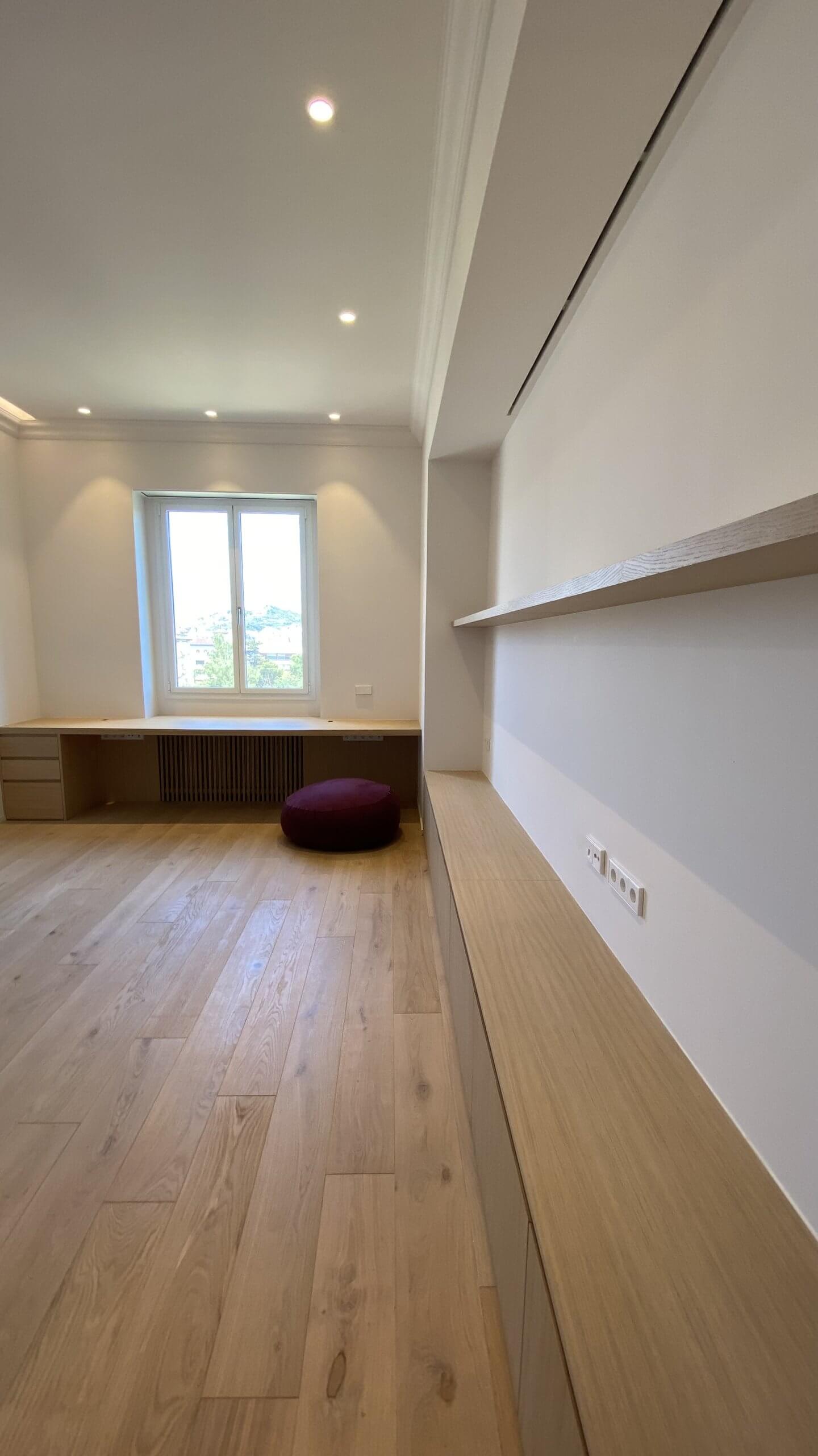 Estudio reformado con escritorio de obra y estantería en vivienda de Muntaner Barcelona