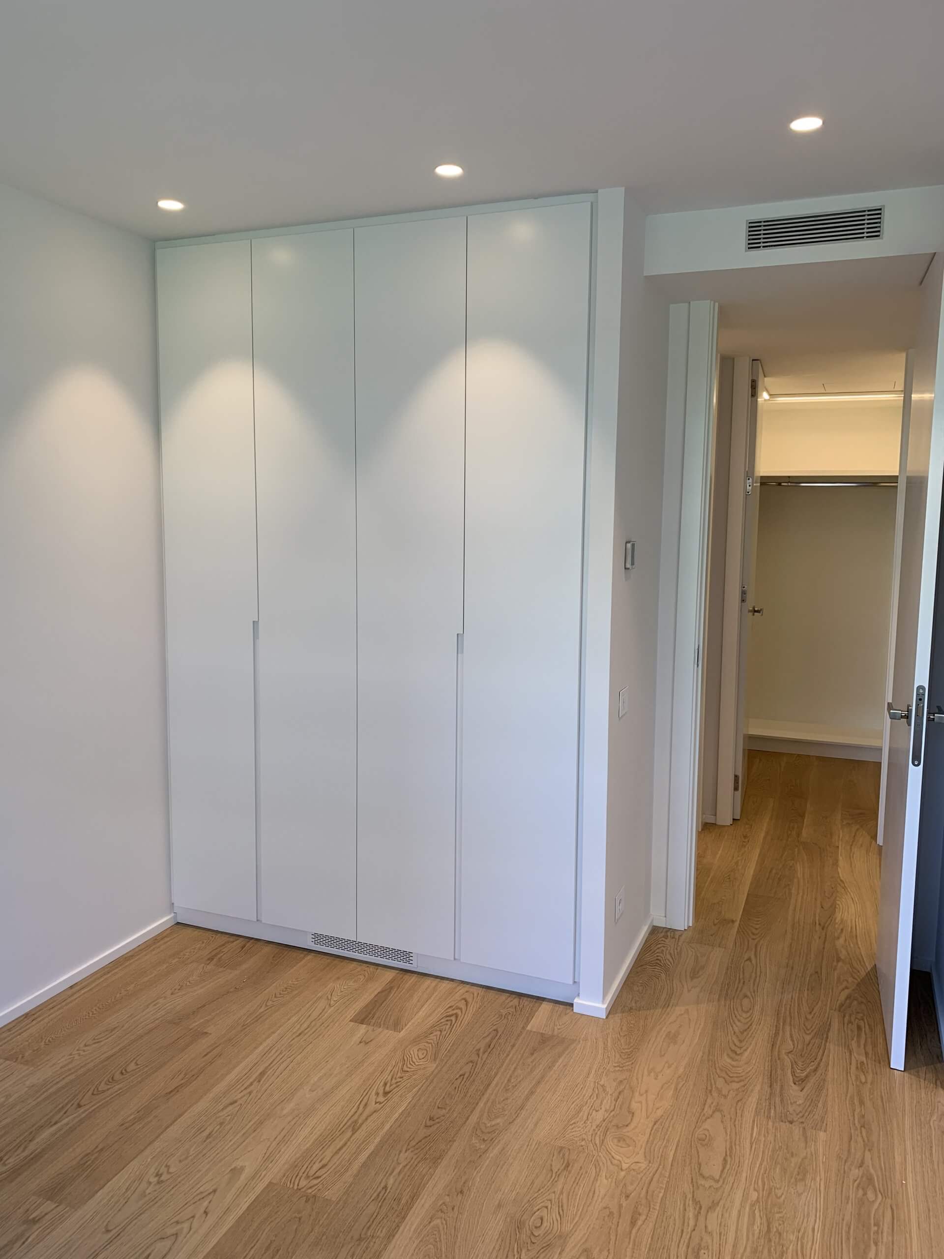 Armario empotrado blanco en dormitorio reformado en Muntaner Barcelona