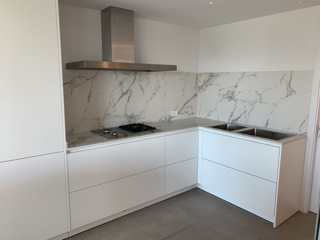 encimera de cocina con placa de gas y fregadero doble en cocina blanca