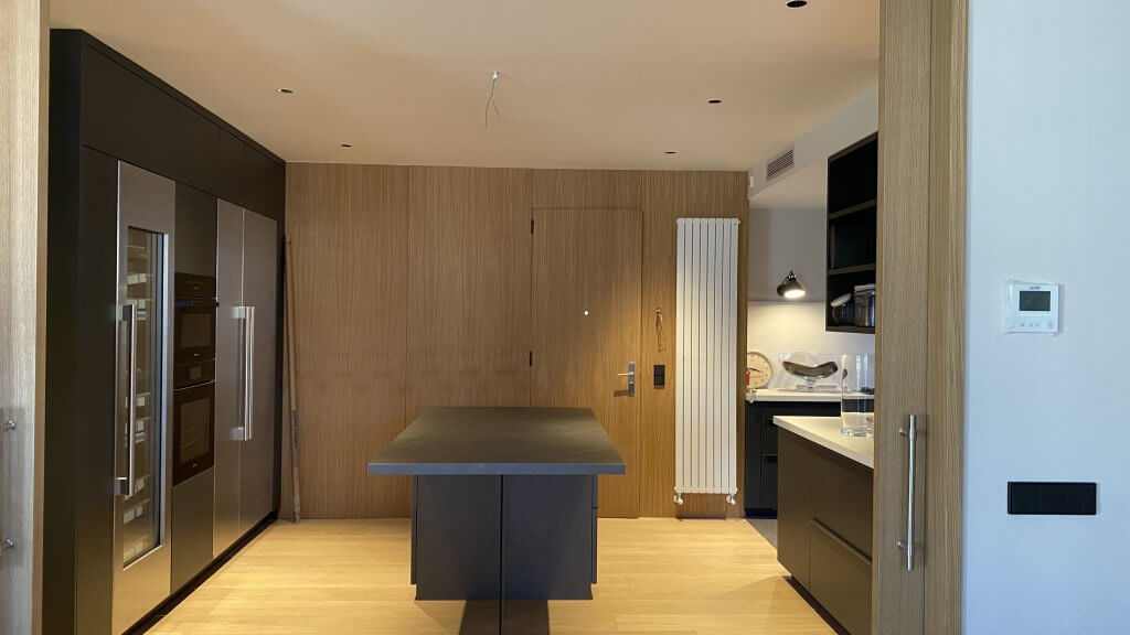 Vista frontal de cocina con isla central y acabados en madera natural - Casa Freixa