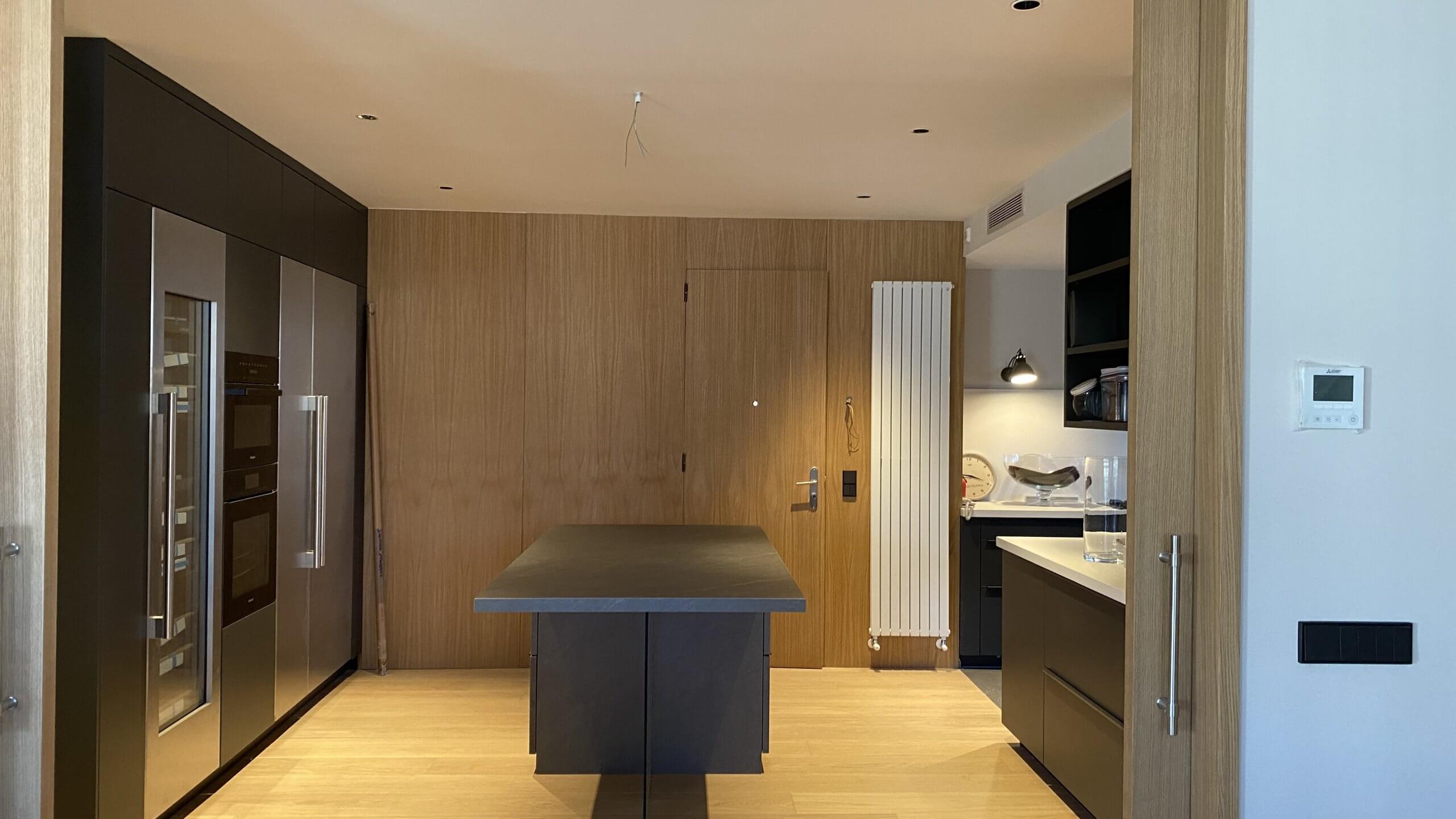 Vista frontal de cocina con isla central y acabados en madera natural - Casa Freixa