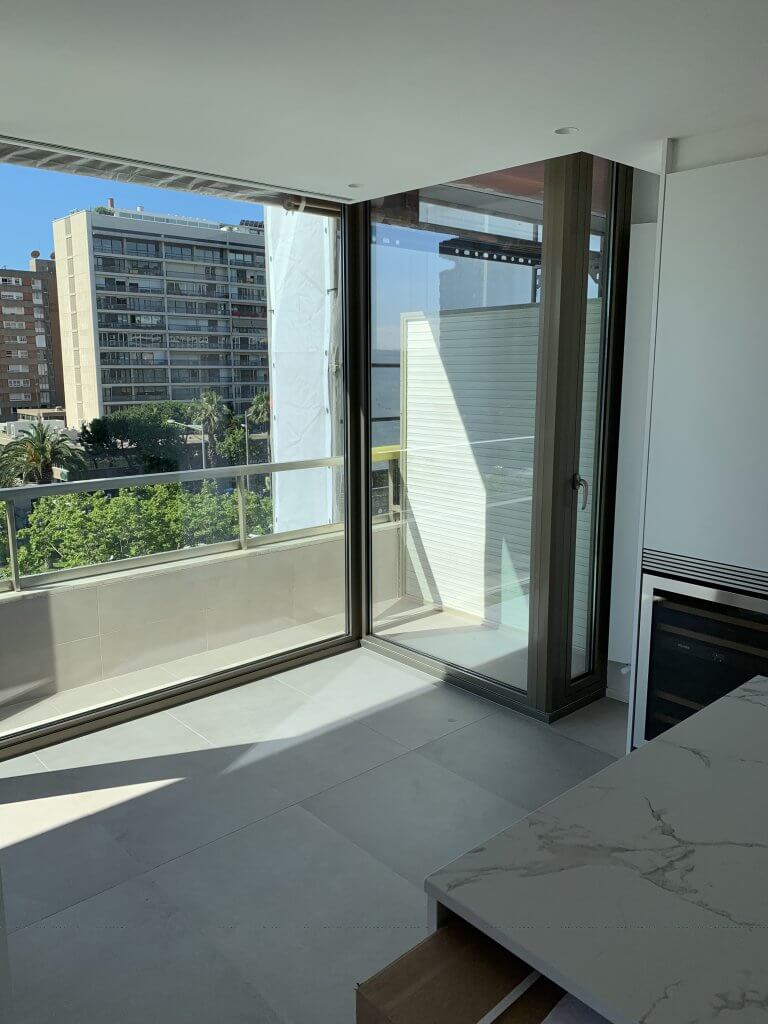 salida a terraza desde cocina moderna con ventanales de cristal corredizos