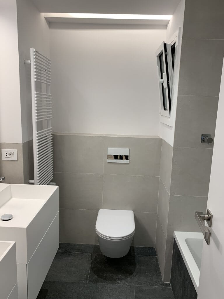 Baño pequeño reformado con inodoro suspendido y estilo moderno en Muntaner Barcelona