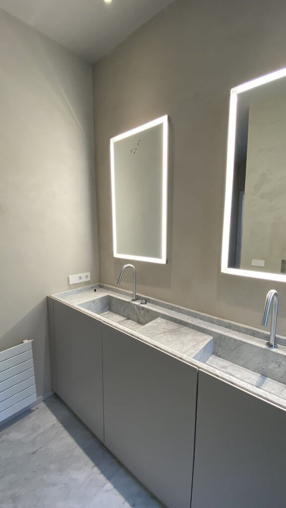 Lavabo doble en mármol con grifería empotrada en reforma de baño en Muntaner