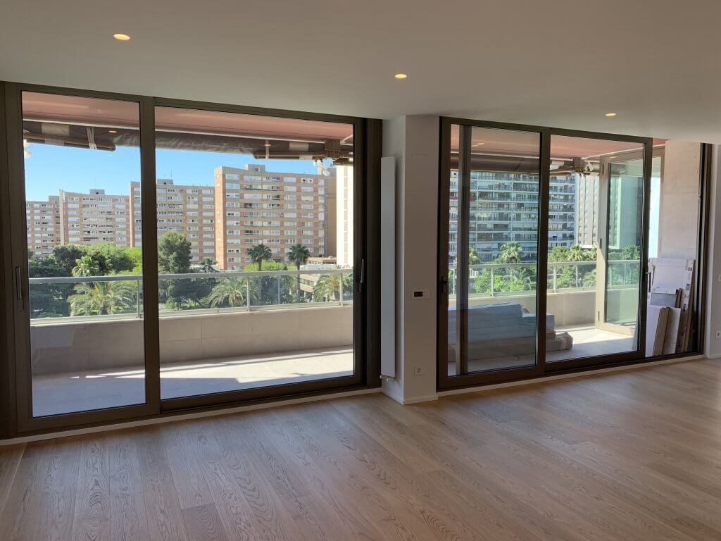salón luminoso con ventanales de aluminio y vistas urbanas en edificio moderno
