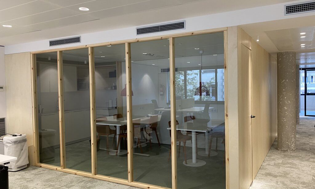Sala de reuniones con mamparas de vidrio y mobiliario de oficina contemporáneo
